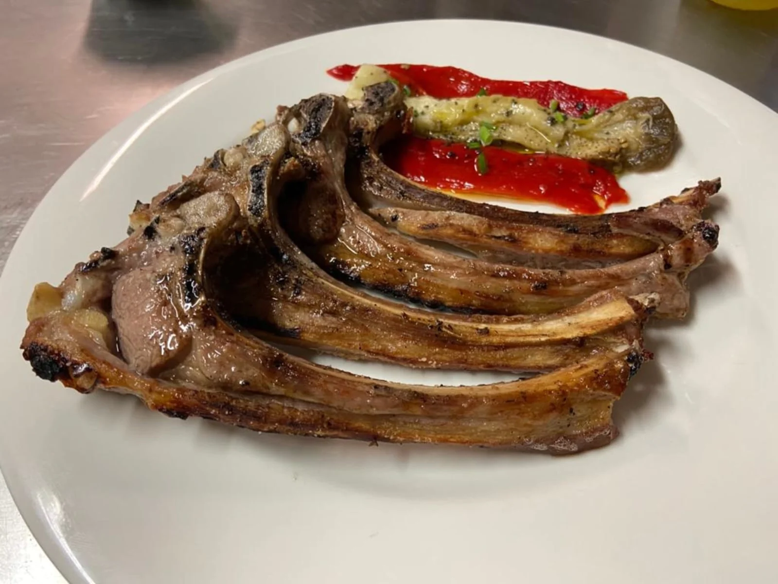Plato de cordero del restaurante en Apartamentos Can Rocamora, Arén
