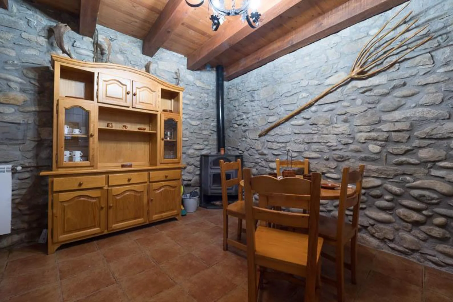 Comedor del bungalow de Casa Alfonso con paredes de piedra y mesa de madera.