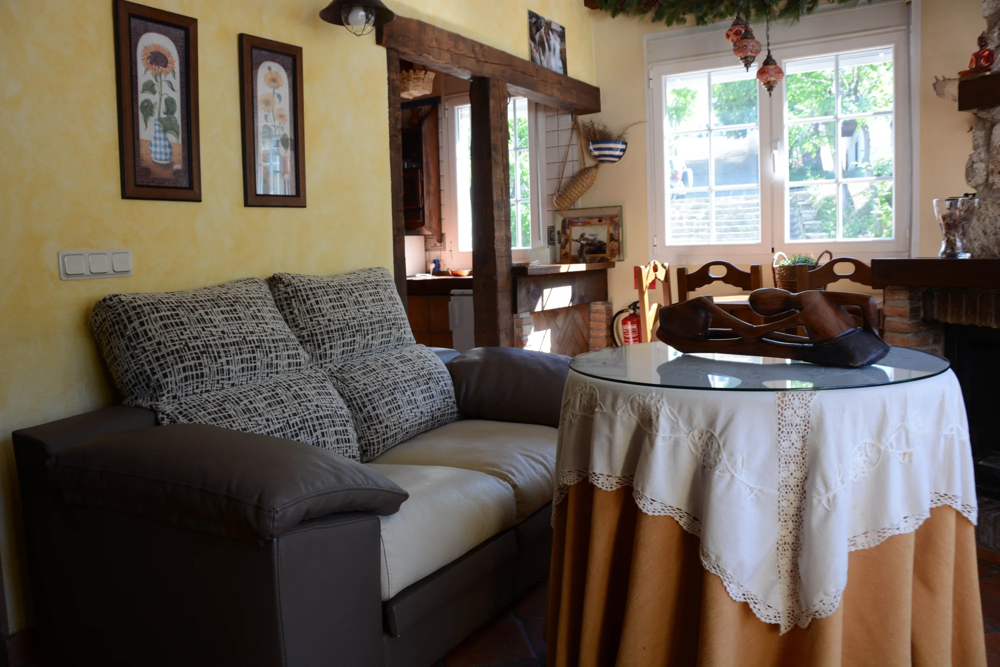 Salón de La Orospeda con sofá y comedor junto a la chimenea