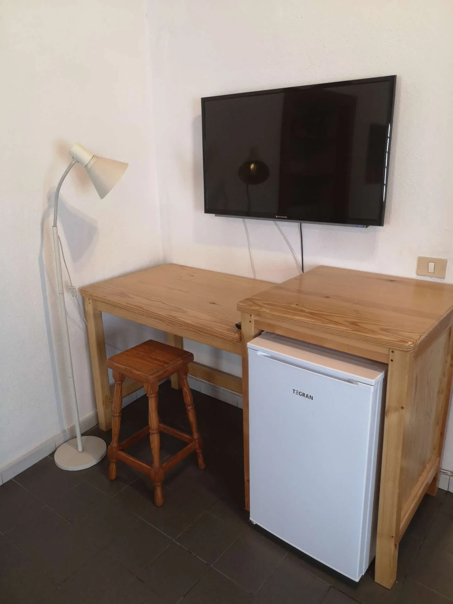 Zona de escritorio, televisión y nevera en el estudio