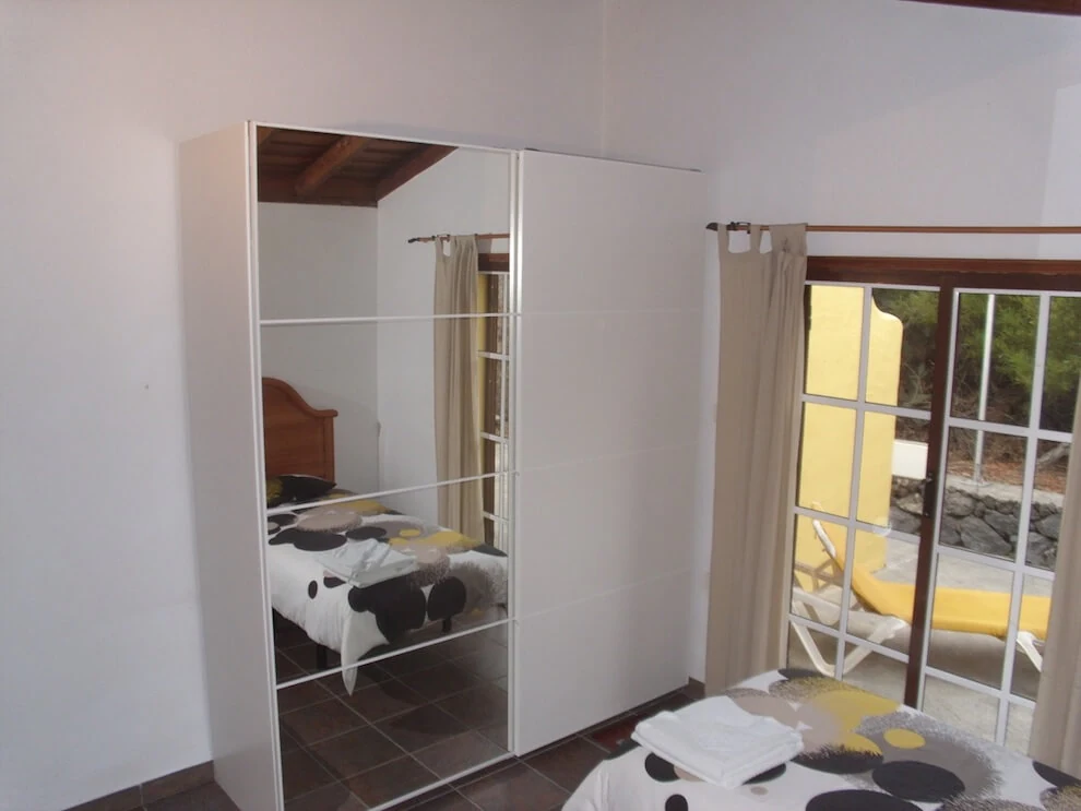 Dormitorio de Casa Conrado con dos camas y salida a la terraza.