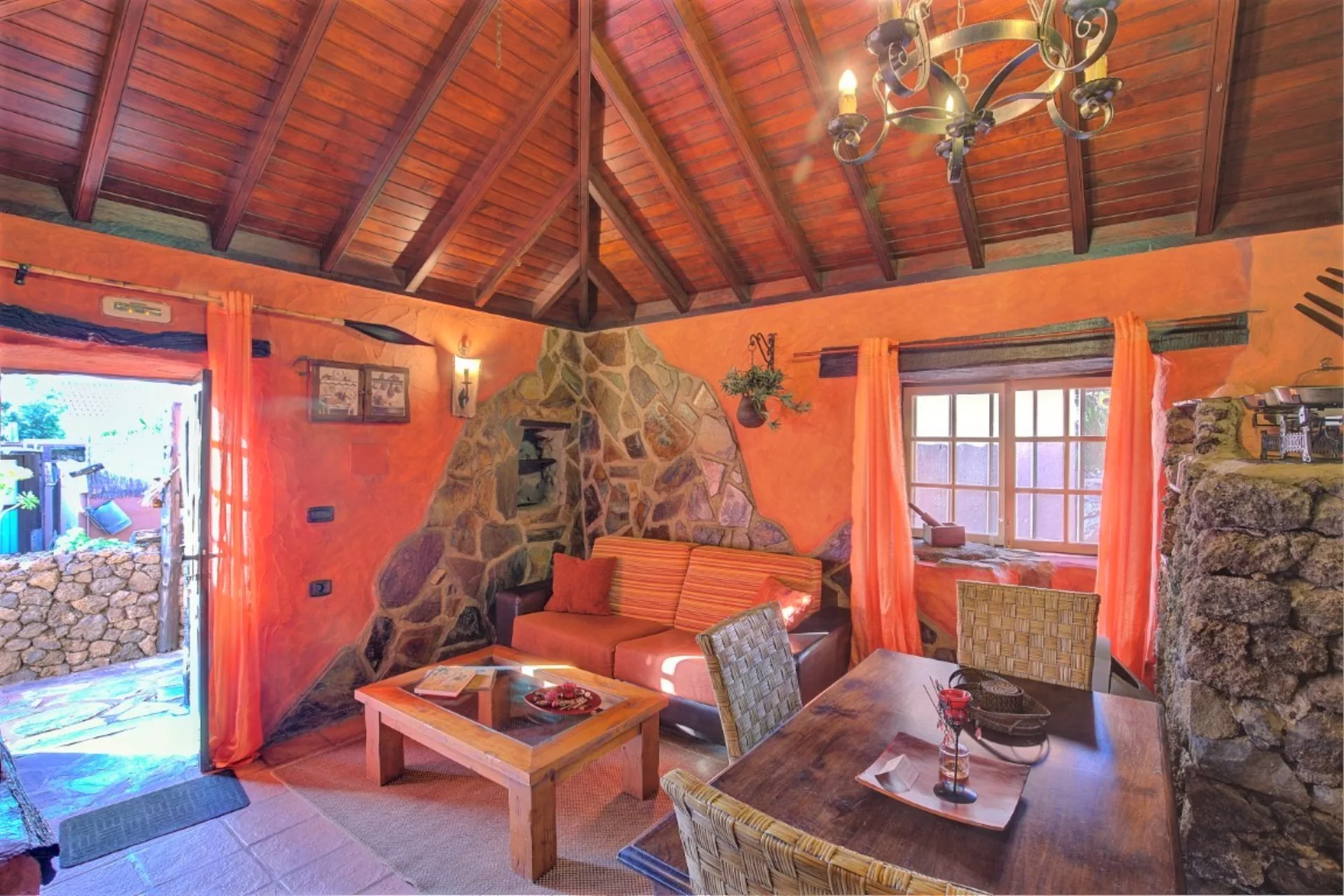 Sala de estar de La Despensa con techo de madera y piedra