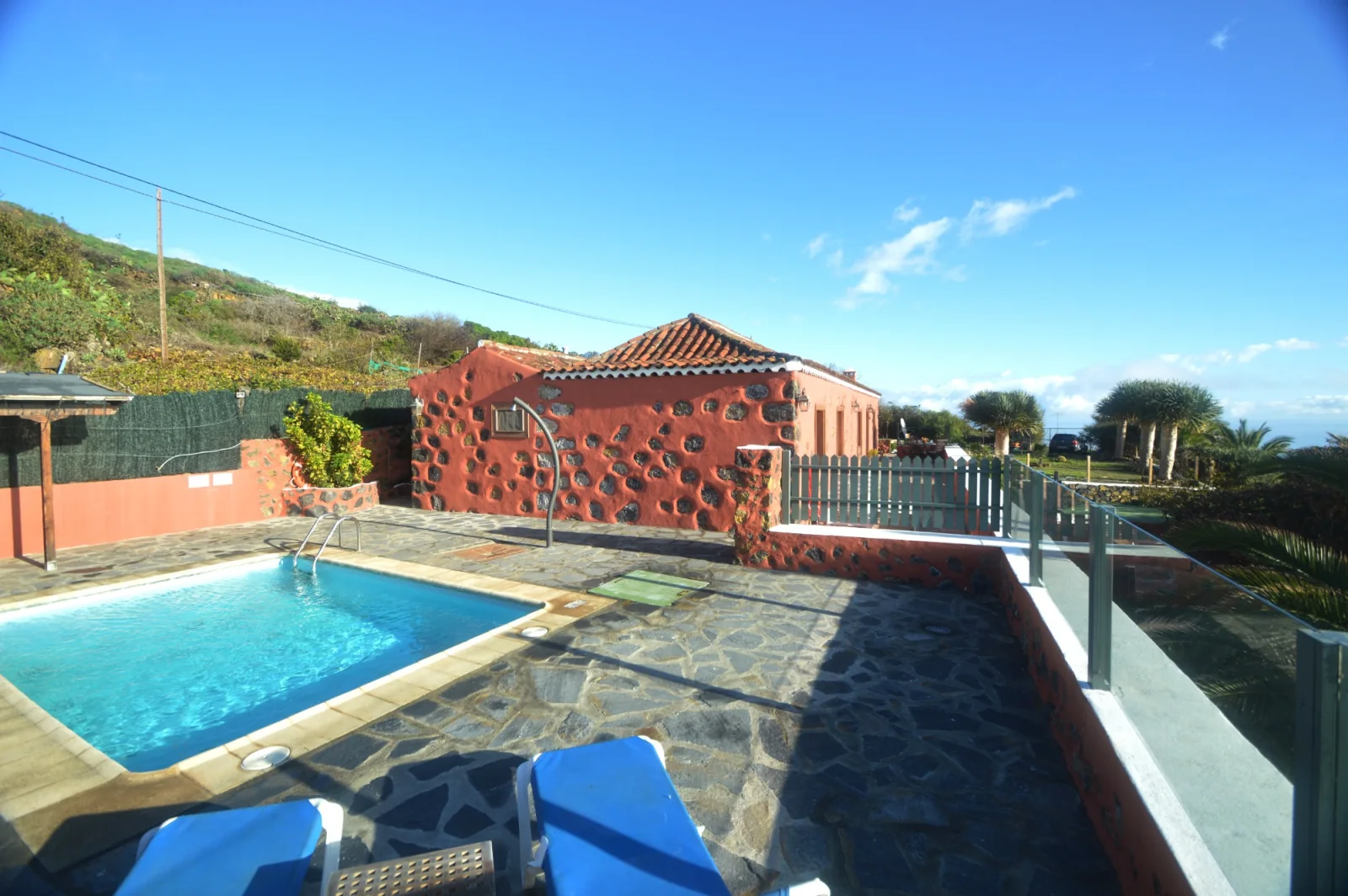 Vista lateral de la casa rural, terraza y piscina