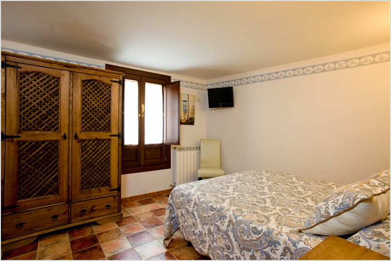 Dormitorio doble con armario de madera de Casa Rural La Cigüeña