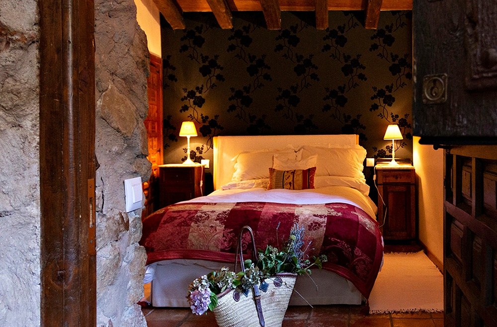 Habitación con textiles granates de Posada de Urreci