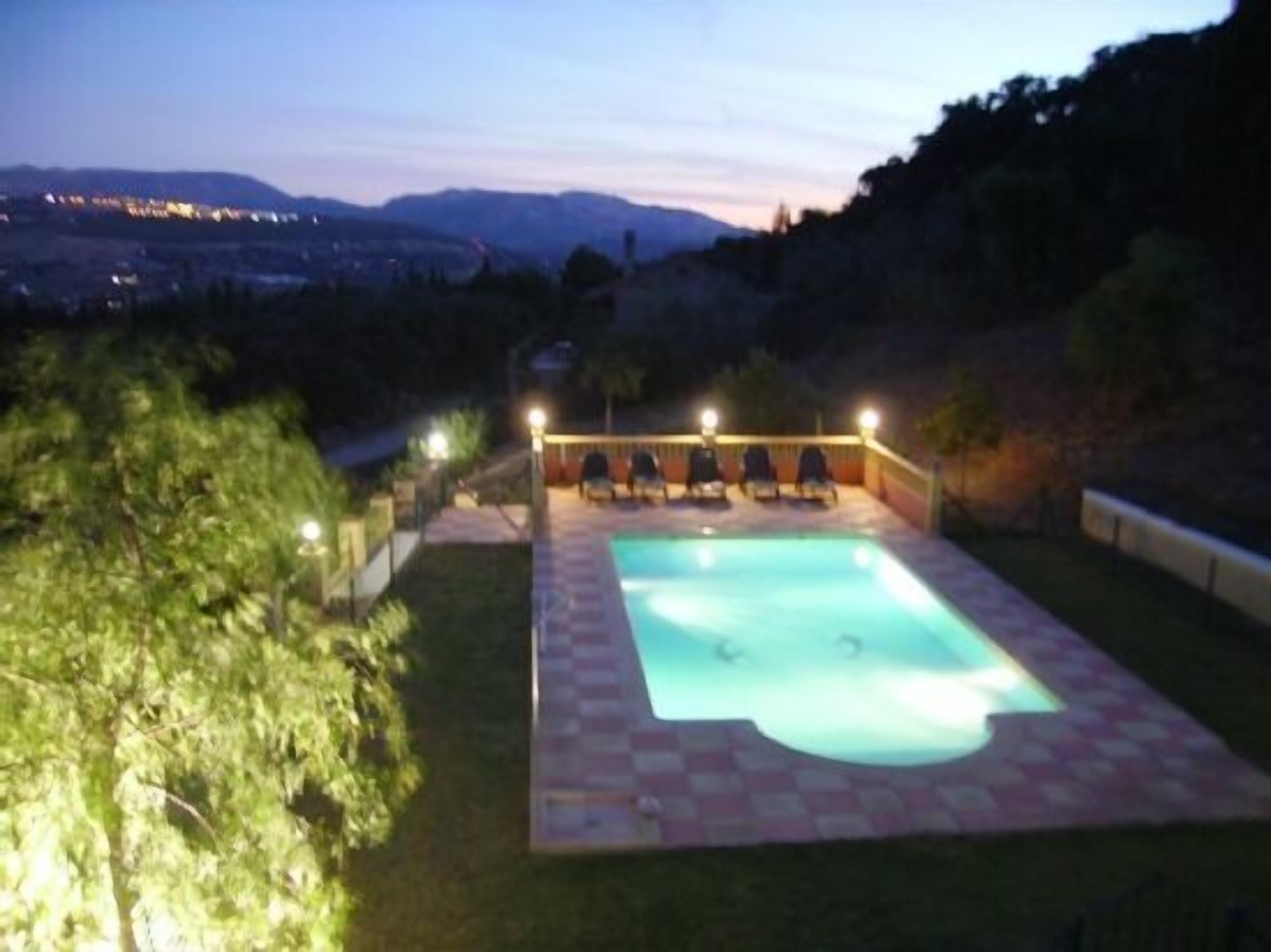 Piscina de Villa Palacios iluminada al anochecer