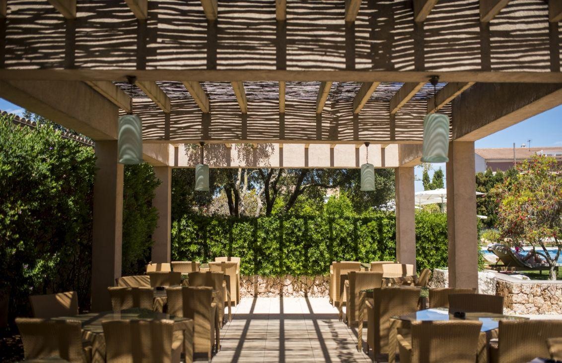 Comedor bajo pérgola en el jardín