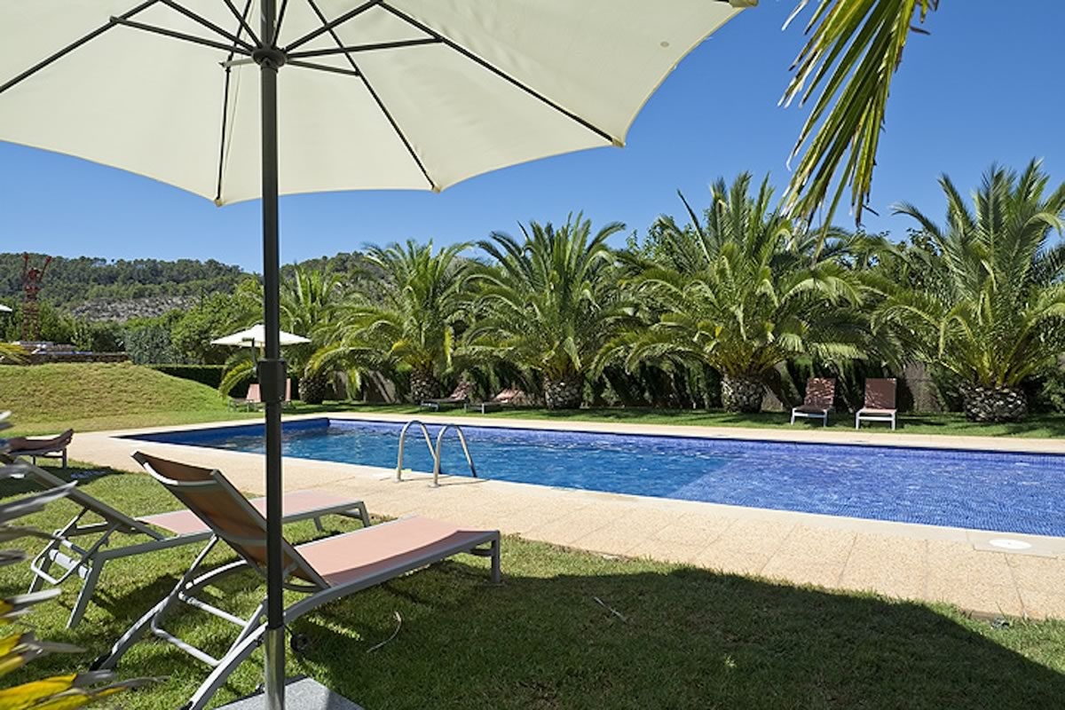 Piscina y palmeras de LoftOtel Canet