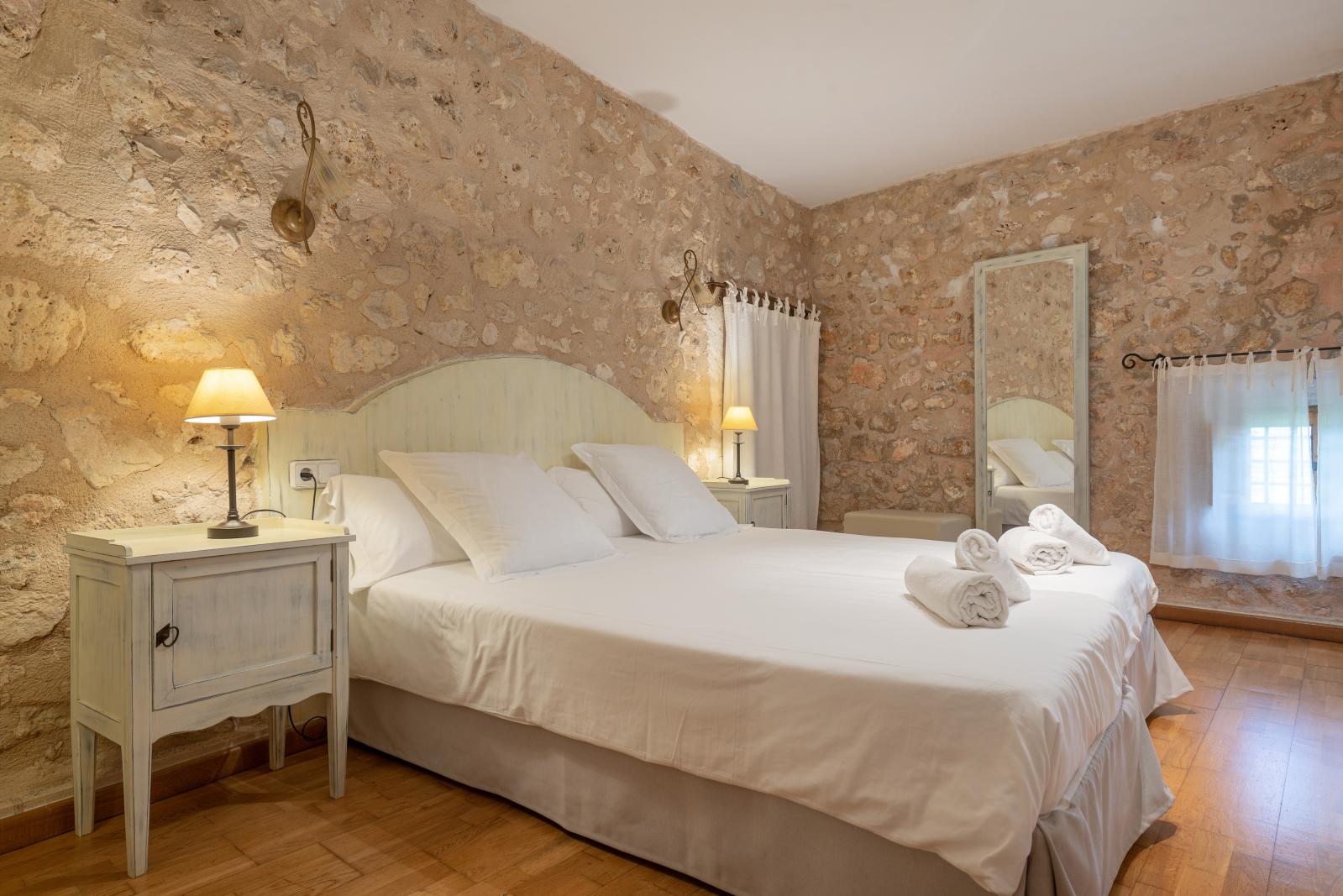 Dormitorio con muro de piedra