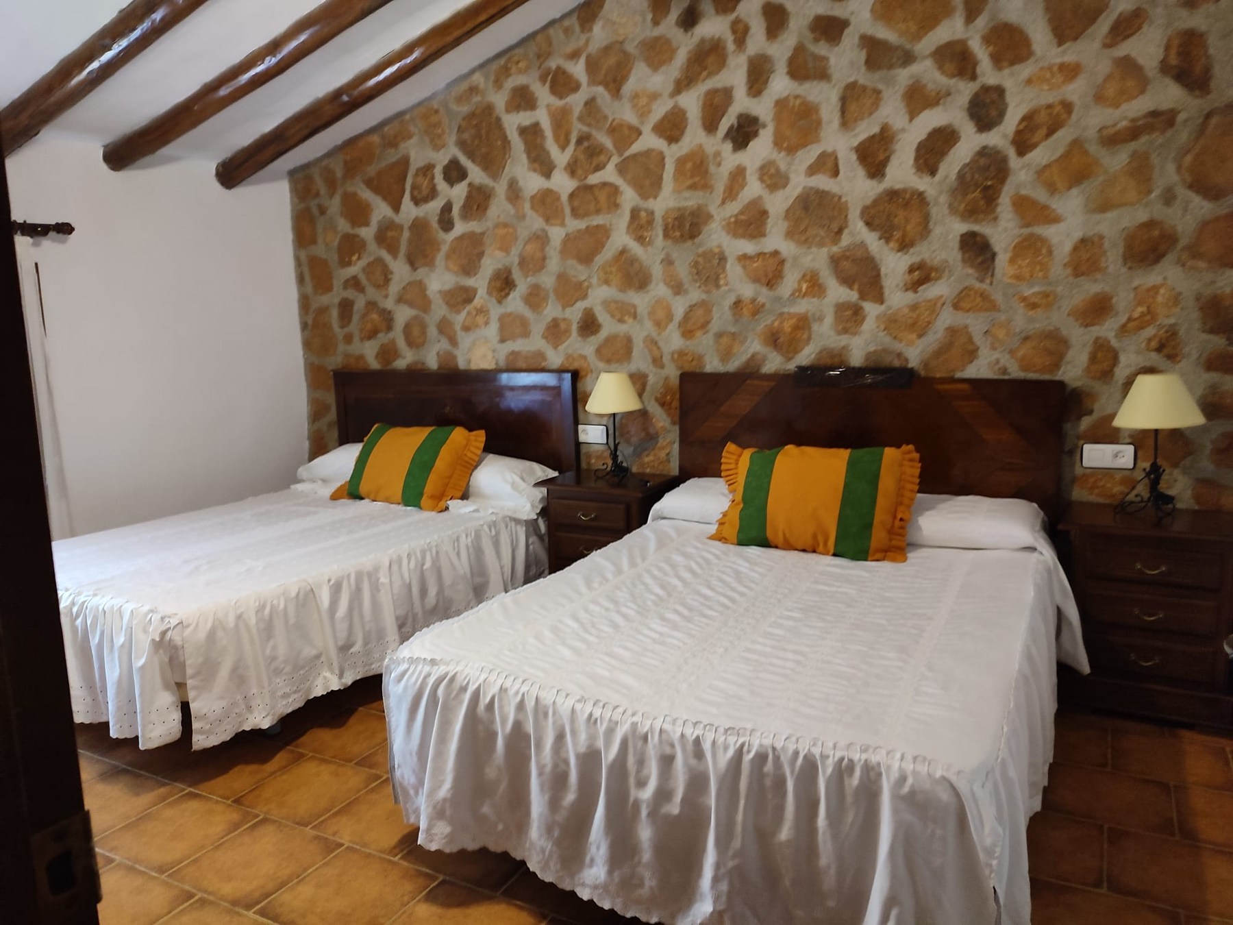 Dormitorio con muro de piedra