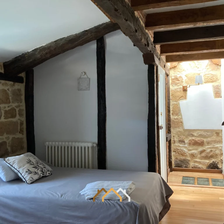 Dormitorio de una de las casas rurales con estructura de madera · Las Casas de Quintanilla