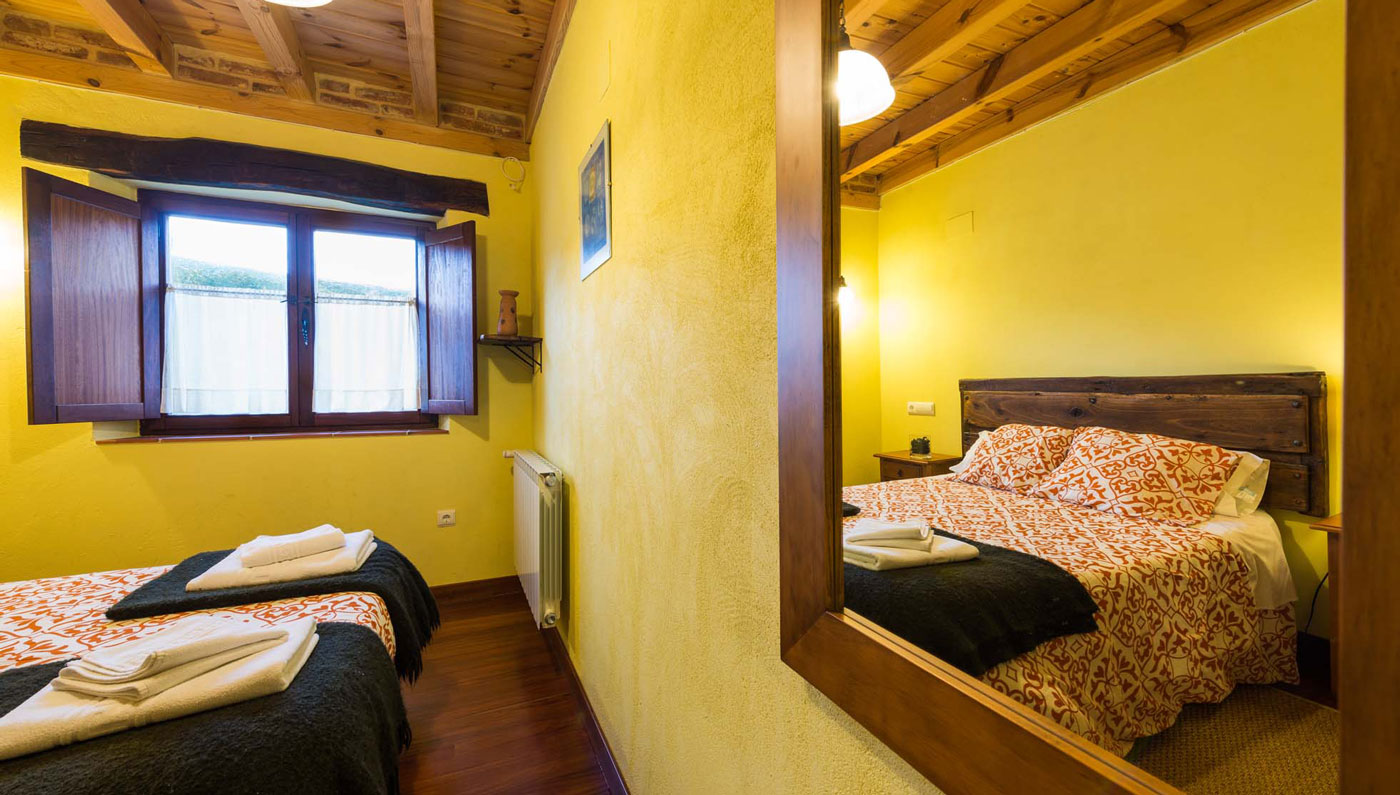 Habitación con camas y acceso al baño en el Hotel Rural Piedra Abierta