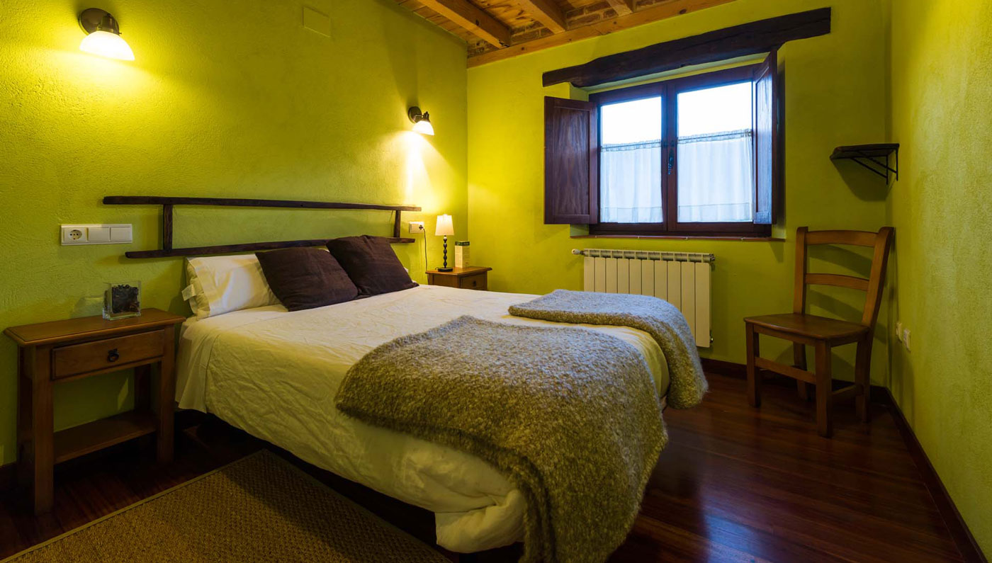 Habitación de matrimonio con vigas de madera en el Hotel Rural Piedra Abierta