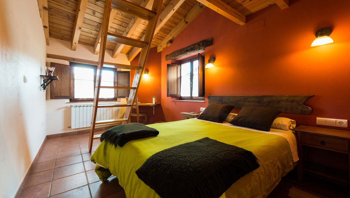 Dormitorio abuhardillado con cama doble en el Hotel Rural Piedra Abierta