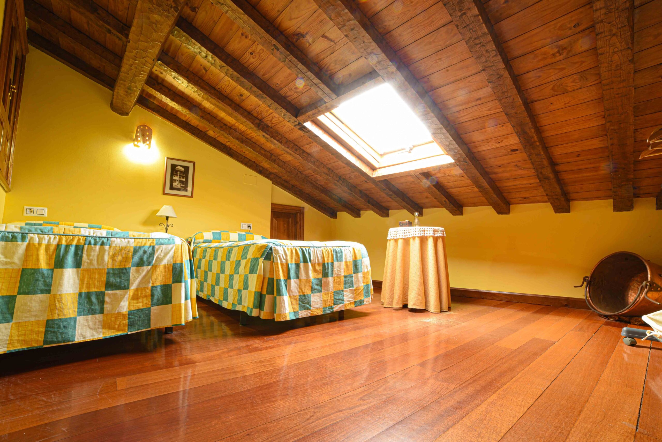 Buhardilla con camas individuales y vigas de madera