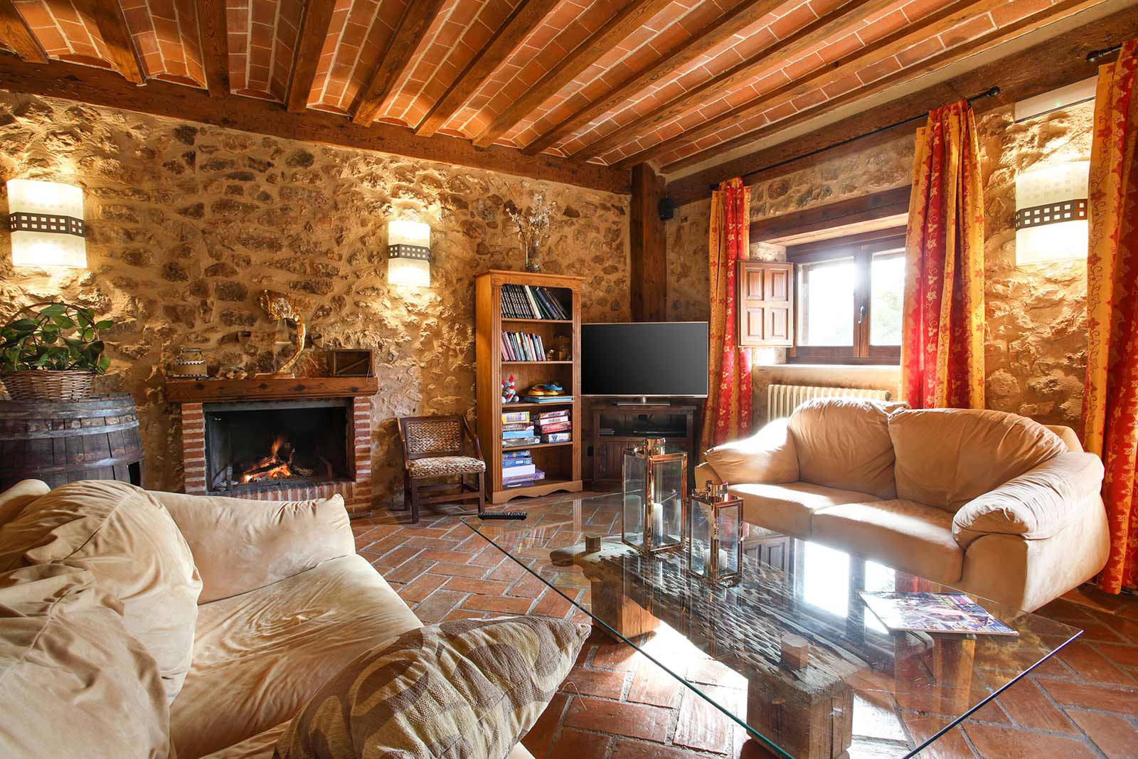 Salón de Posada Real Los Templarios con chimenea y pared de piedra