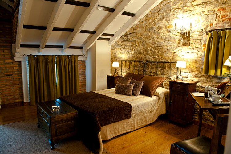 Habitación con pared de piedra y vigas de madera